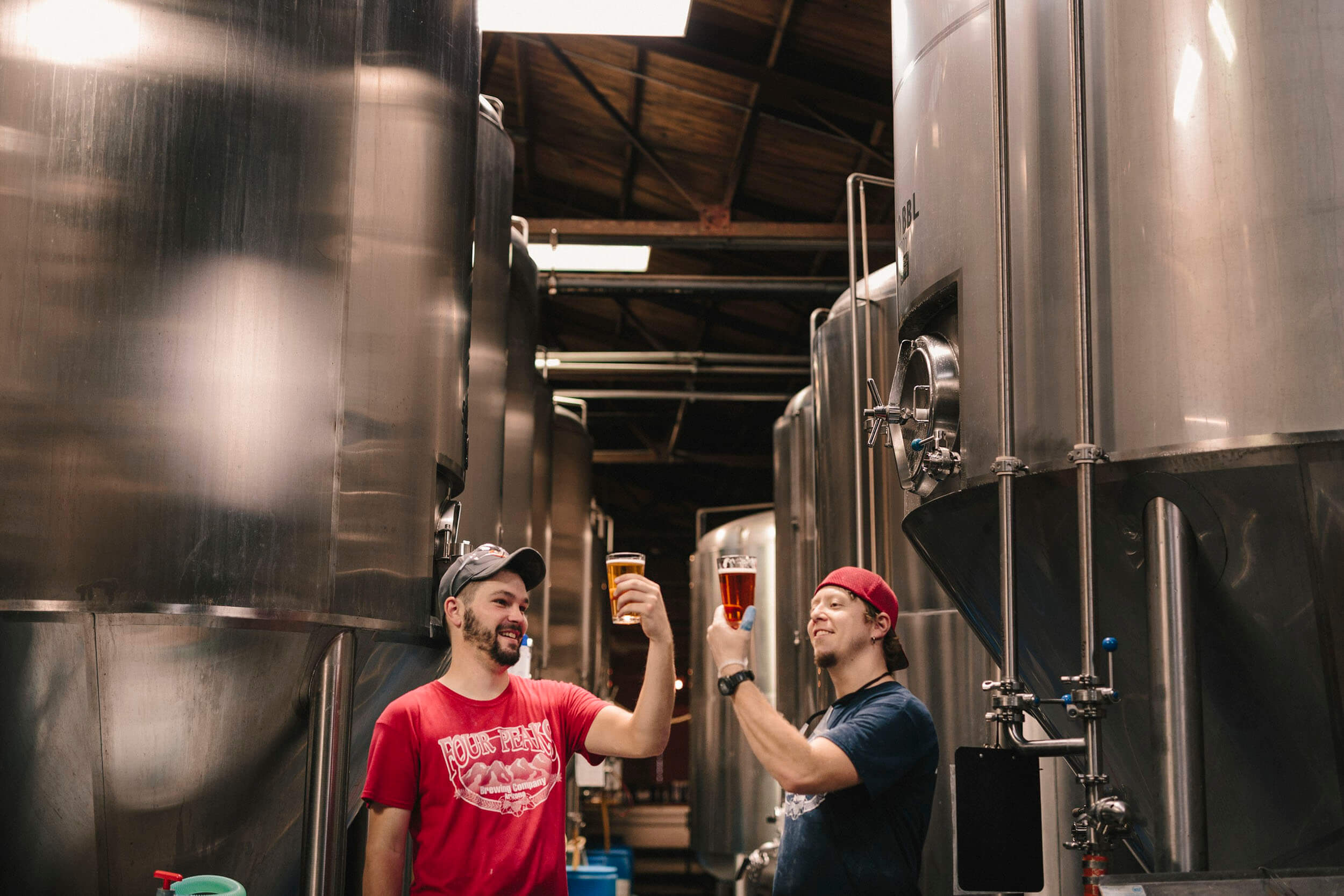 Brewers surrounded by fermentation tanks